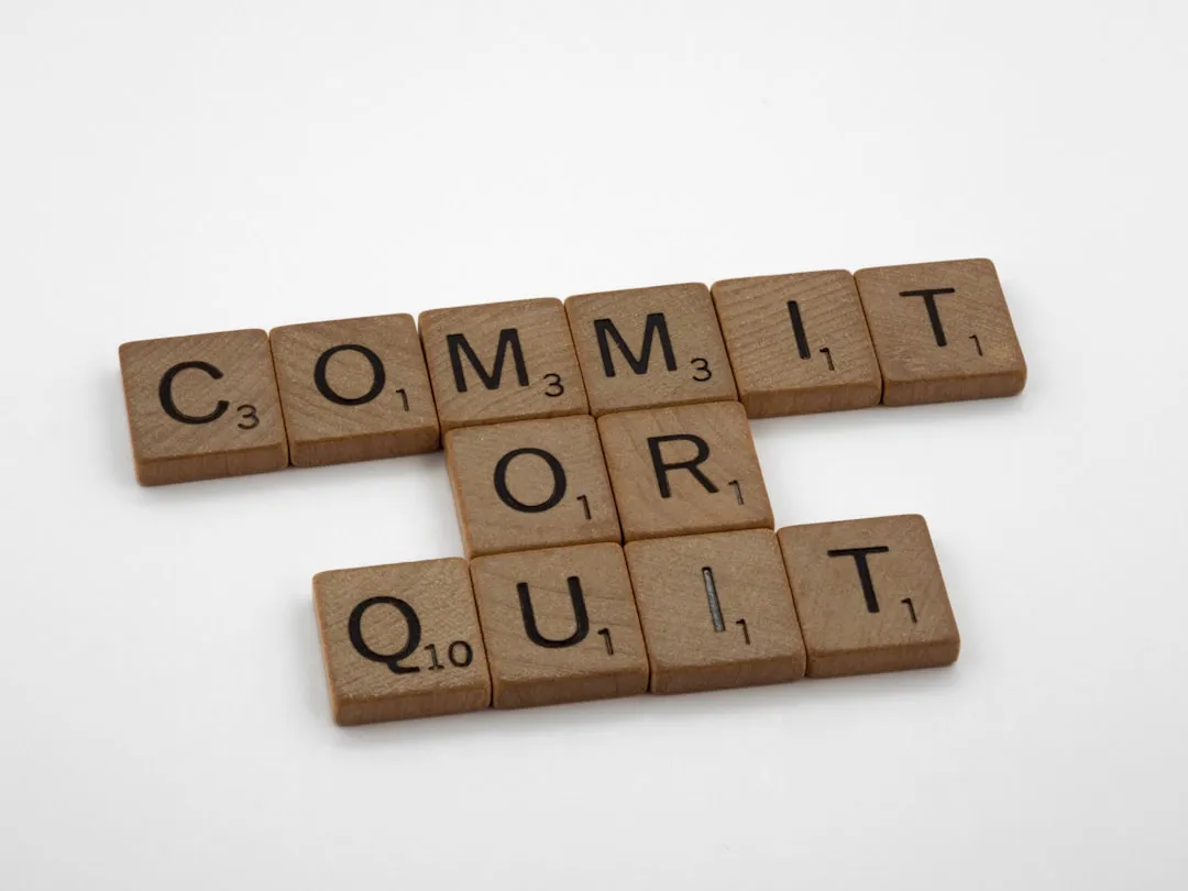 a scrabble of words spelling commit or quit out