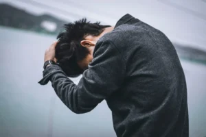 man in black long sleeve shirt covering his face