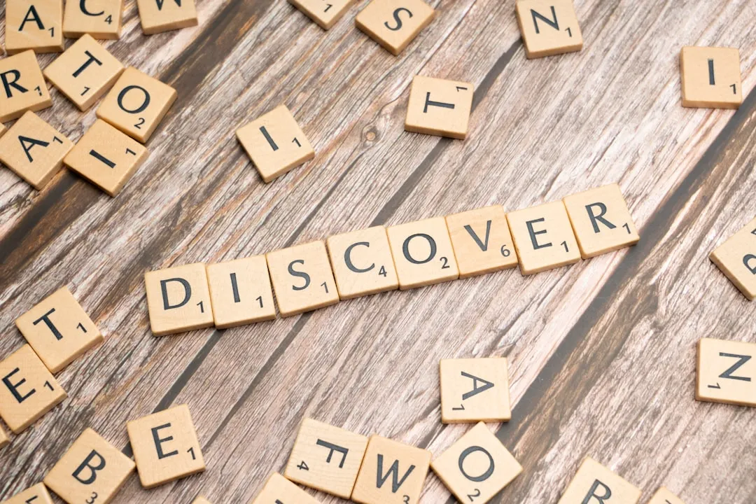 scrabble tiles spelling the word discovery on a wooden surface