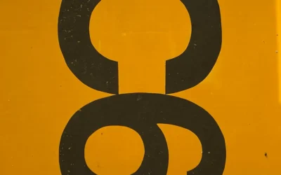 a close up of a yellow sign with a black letter
