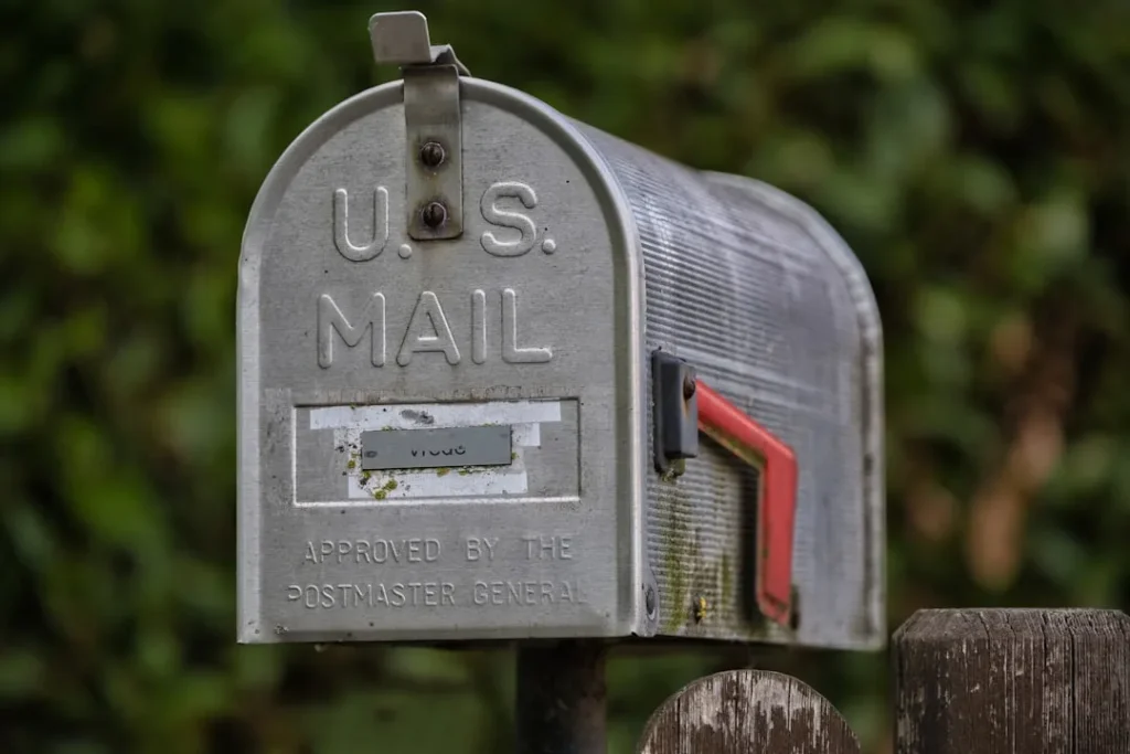A weathered u.s. mailbox with a red flag.