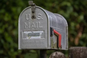 A weathered u.s. mailbox with a red flag.